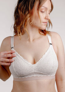 Model wearing Valeria nursing bra in ivory reaching for the magnetic clip