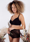 Model standing amongst dried flowers wearing Valeria nursing bra and Amelie high waist in colour black