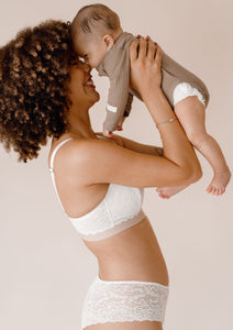 Mother holding her baby wearing Valeria nursing bra and Leia hipster in ivory