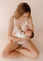 Mother holding her sleeping baby wearing Vienna nursing bra and Lemonie high waist in colour ivory